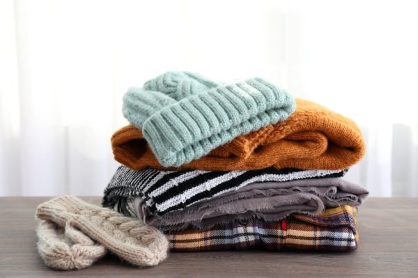 Concept of winter clothes on wooden table.